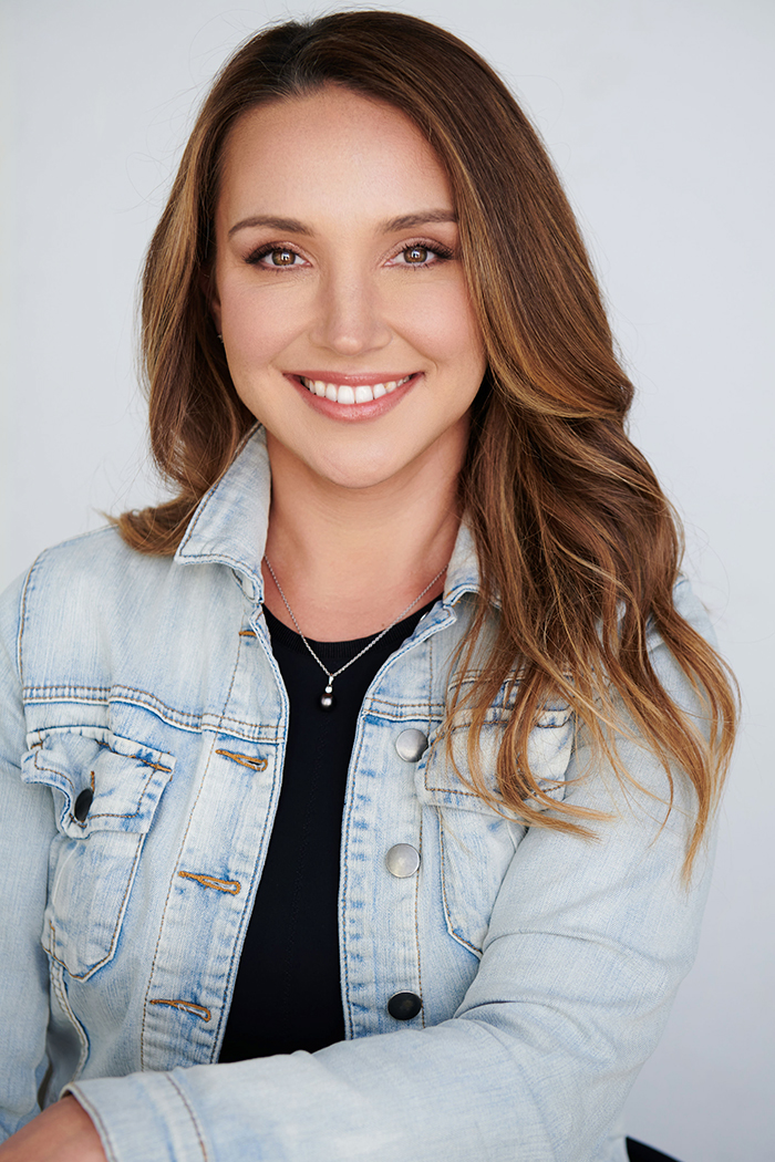Professional woman in a denim jacket smiling at the camera